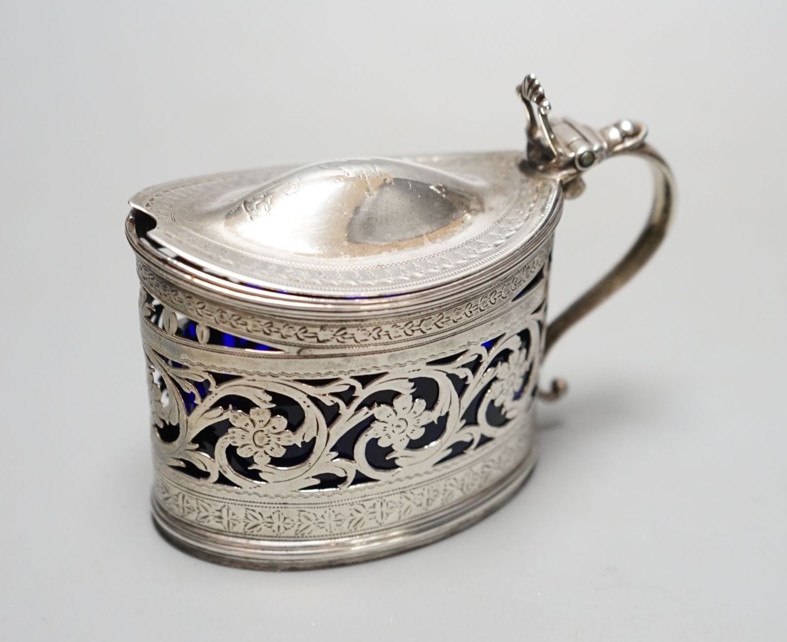 A George III engraved and pierced silver oval mustard pot, Michael Plummer, London, 1793, length 10cm.